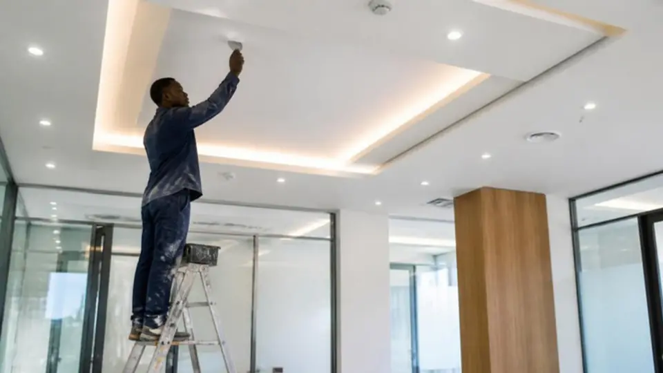 Tecto falso em gesso cartonado com iluminação LED embutida num escritório moderno